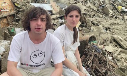 Gli adolescenti spalano il fango nelle terre alluvionate